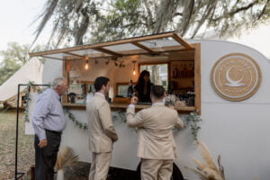 Groom and guest being served at a mobile bar.