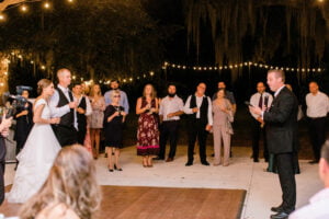 Bride and Groom watch best man give his wedding speech during the reception at All4One Farms wedding venue.