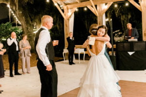 Bride embraces her maid of honor at reception at All4One Farms.