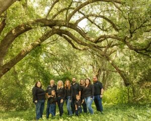 Family gathered under the limbs of an oak tree at All4One Farms.