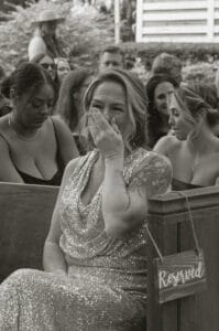 Emotions run high as a mother of the groom covers her mouth and cries when seeing her son take his place at the alter at All4One Farms in Jacksonville, FL.