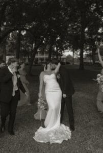 Bride and Groom kiss in front of the manor house at All4One Farms wedding venue.