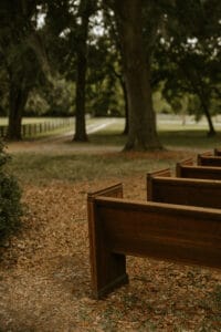 Antique oak pews set up for an outdoor wedding ceremony at All4One Farms.