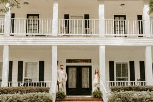 Bride and Groom on the front porch of the manor house at All4One Farms.