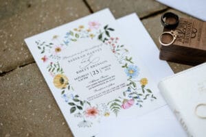 Wedding invitation with spring flower as a border on a brick walkway