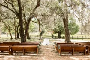 Antique oak pews and wooden arch set up for a wedding ceremony at All4One Farms