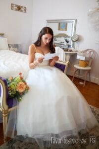 Bride reads a private note from her groom in the bridal suite at All4One Farms