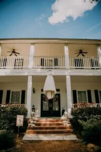 Wedding gown hung from porch roof at Jax wedding venue.