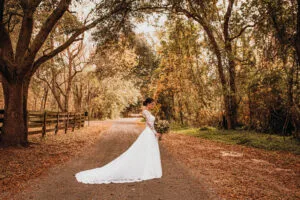 Bride in leaf-covered roadway at Jax wedding venue