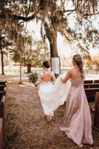 Jax wedding venue - bride with bridesmaid carrying train